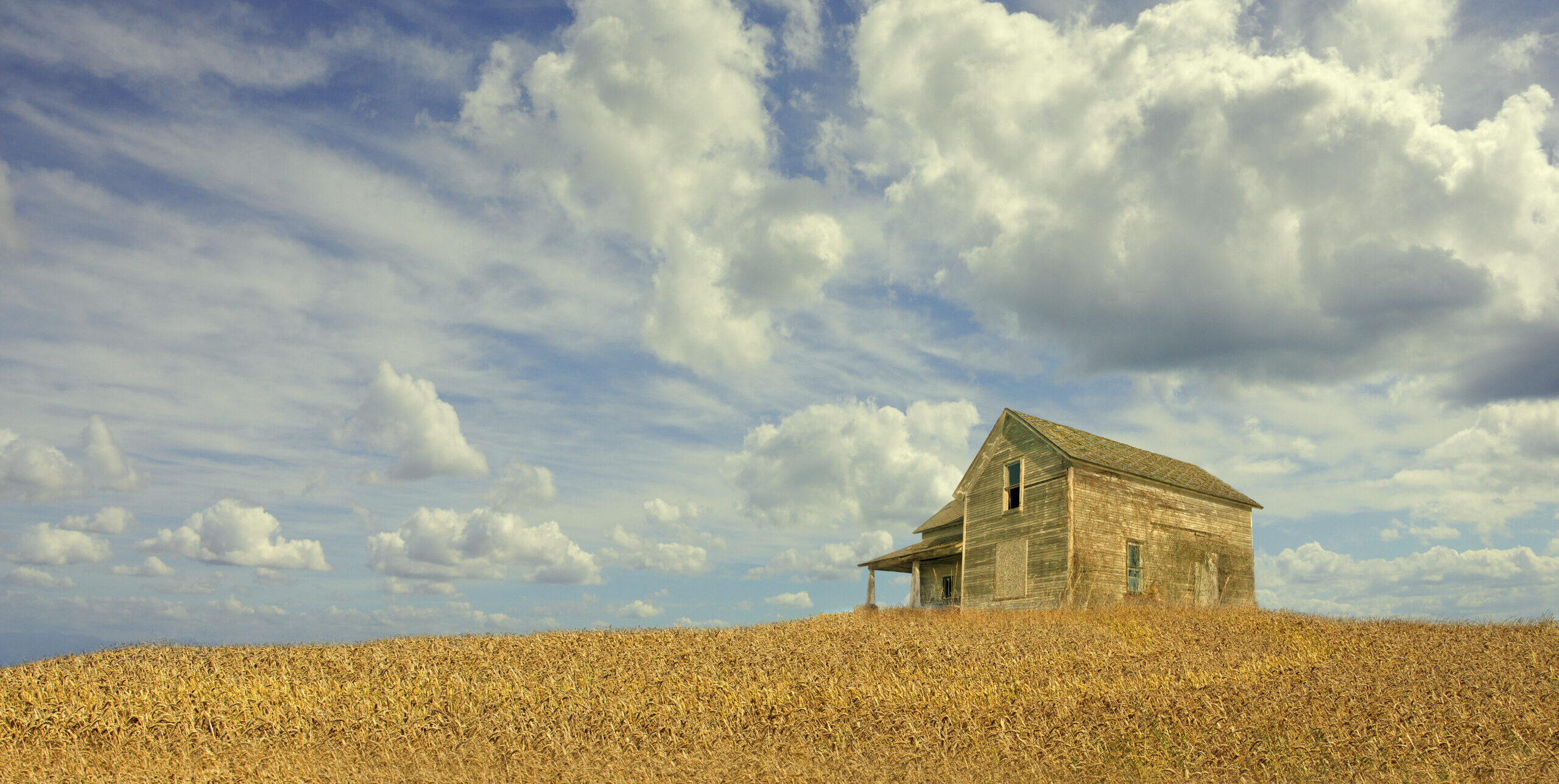 Clouds over remote wooden farmhouse (Chris Clor/Tetra Images via Getty Images)