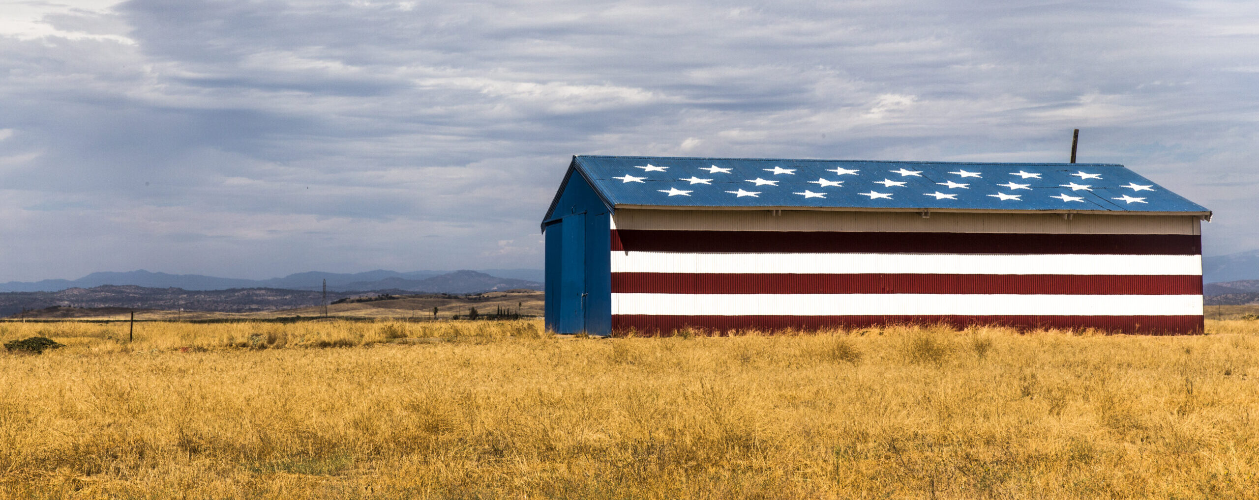 Barn in field painted with stars and stripes, California, USA (Aziz Ary Neto/Image Source via Getty Images)