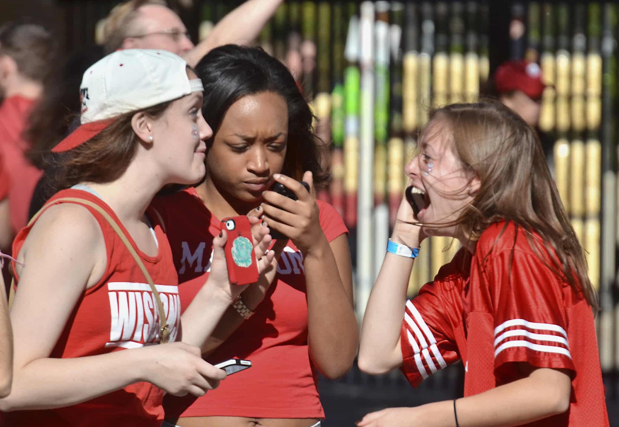 Three young women Wisconsin Badgers fans with phones, October 12, 2013 (Richard Hurd/Flickr/https://creativecommons.org/licenses/by/2.0/)