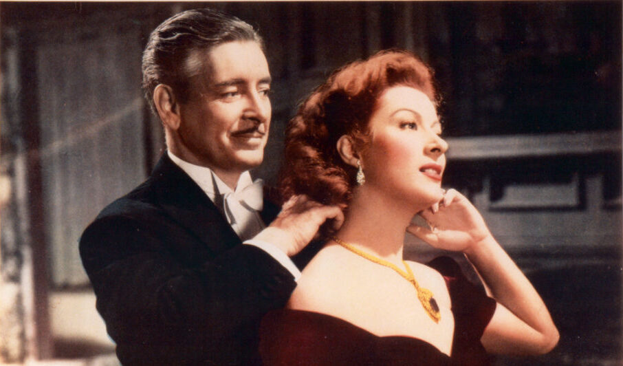 Ronald Colman adjusting necklace on Greer Garson in movie art for the film 'Random Harvest', 1942. (Photo by Metro-Goldwyn-Mayer/Getty Images)