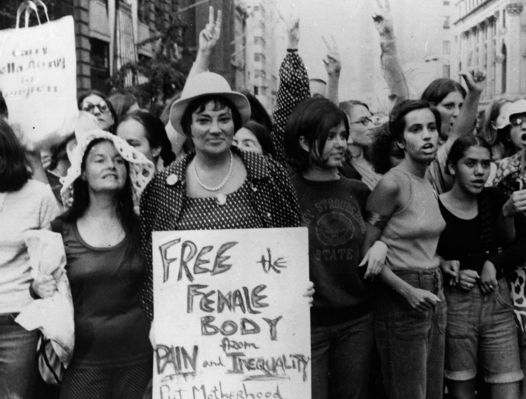 Feminists walk down the street holding signs