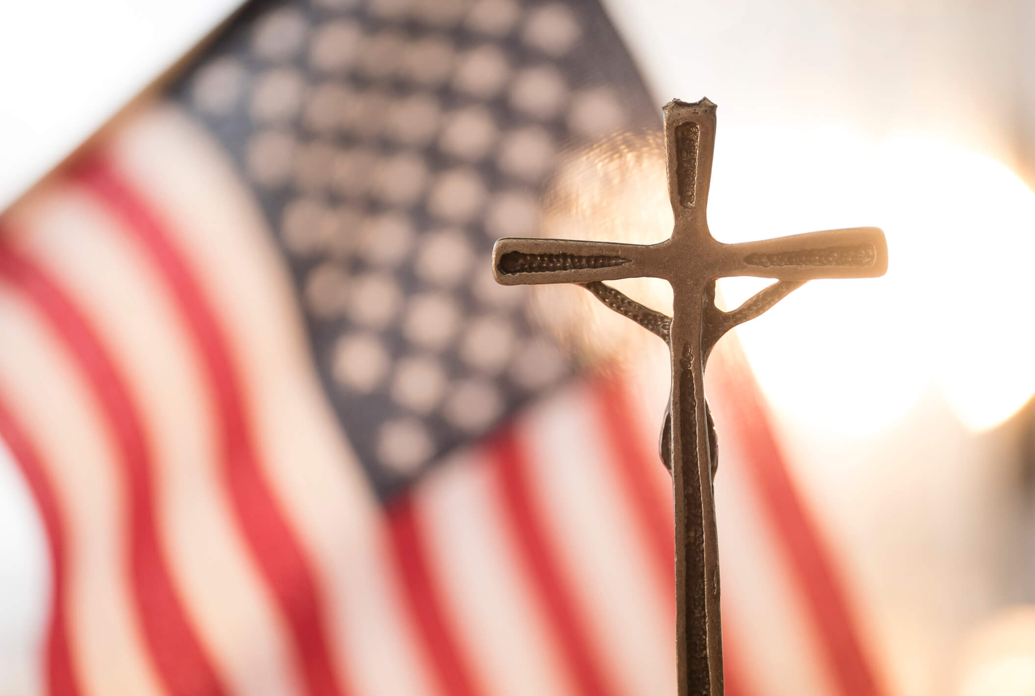 Cross with flag in background (Tetra Images/Getty Images)