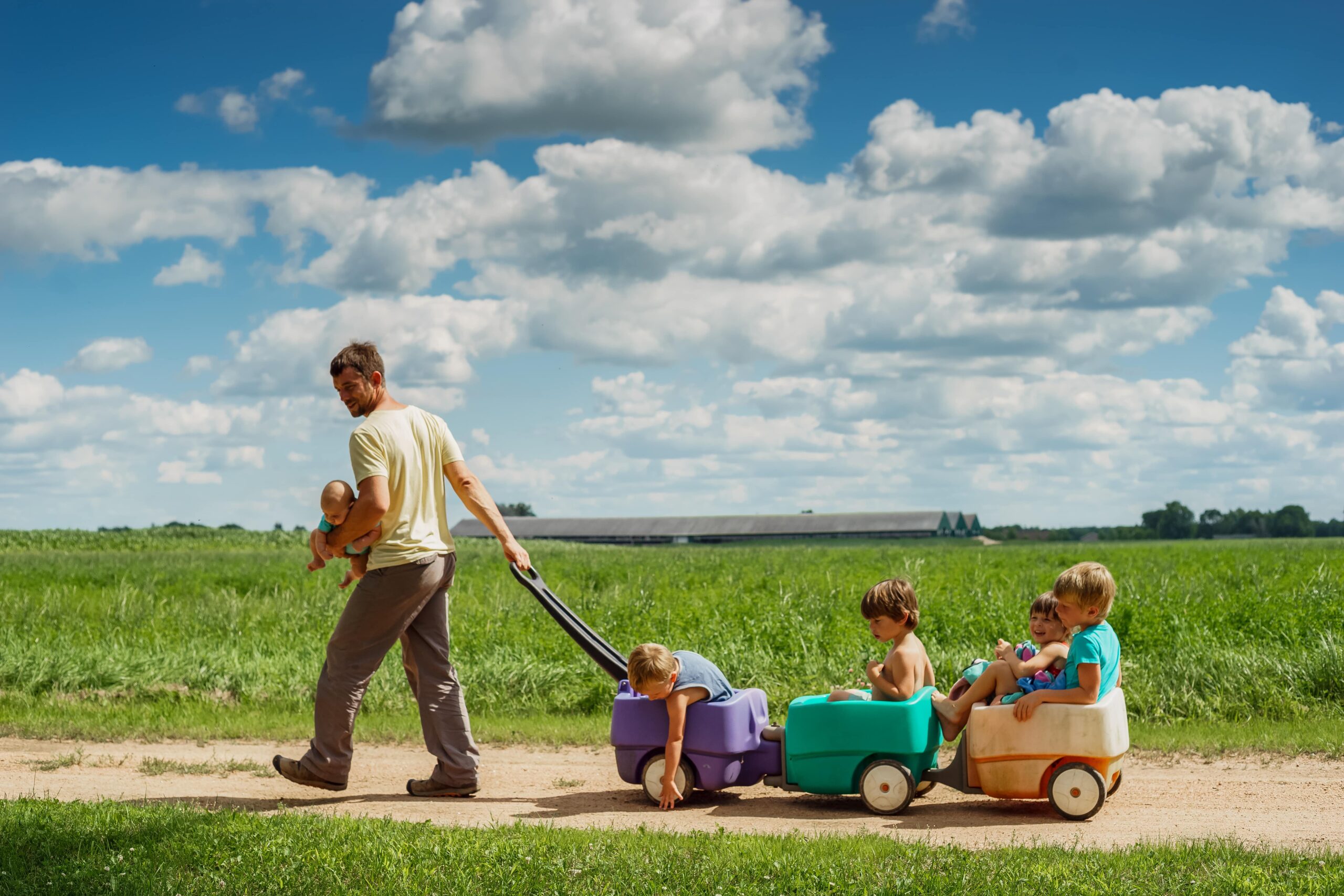 A father pulls several kids in a wagon